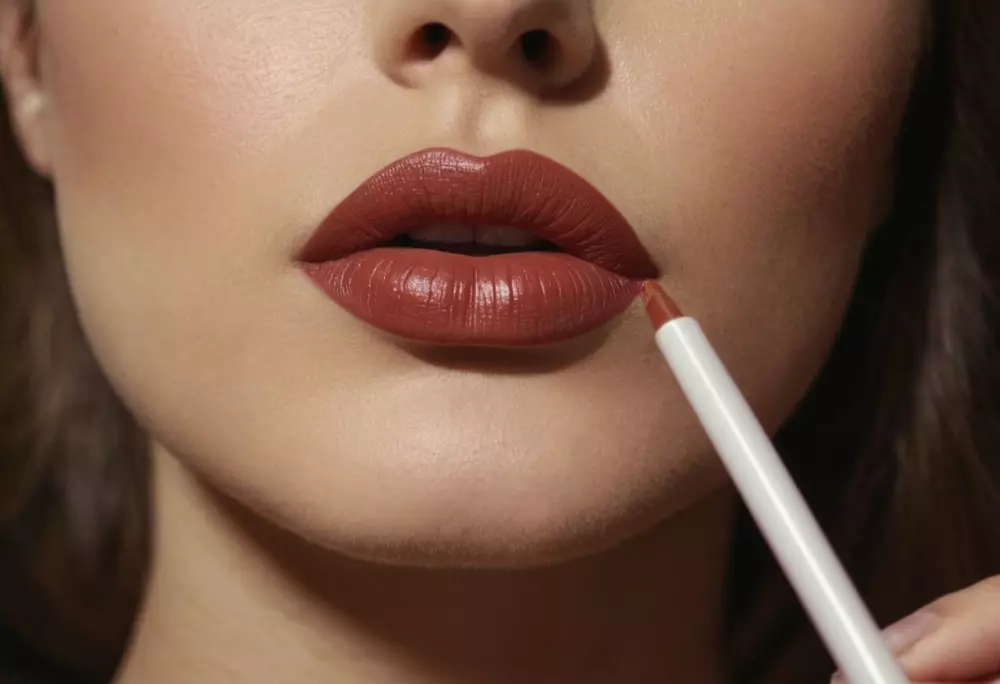 Close-up of a woman using lip liner to outline her lips, focusing on the tip of the liner touching the lip edge, indoor setting, with soft lighting, Photographic, captured in high resolution with a macro lens.