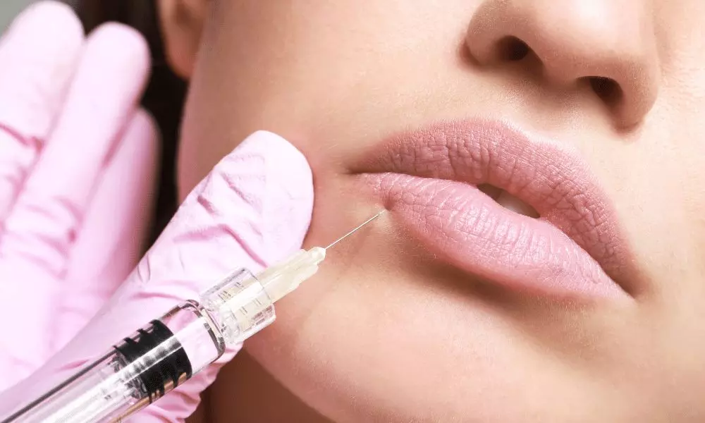 a woman getting a lip injection with a syringe