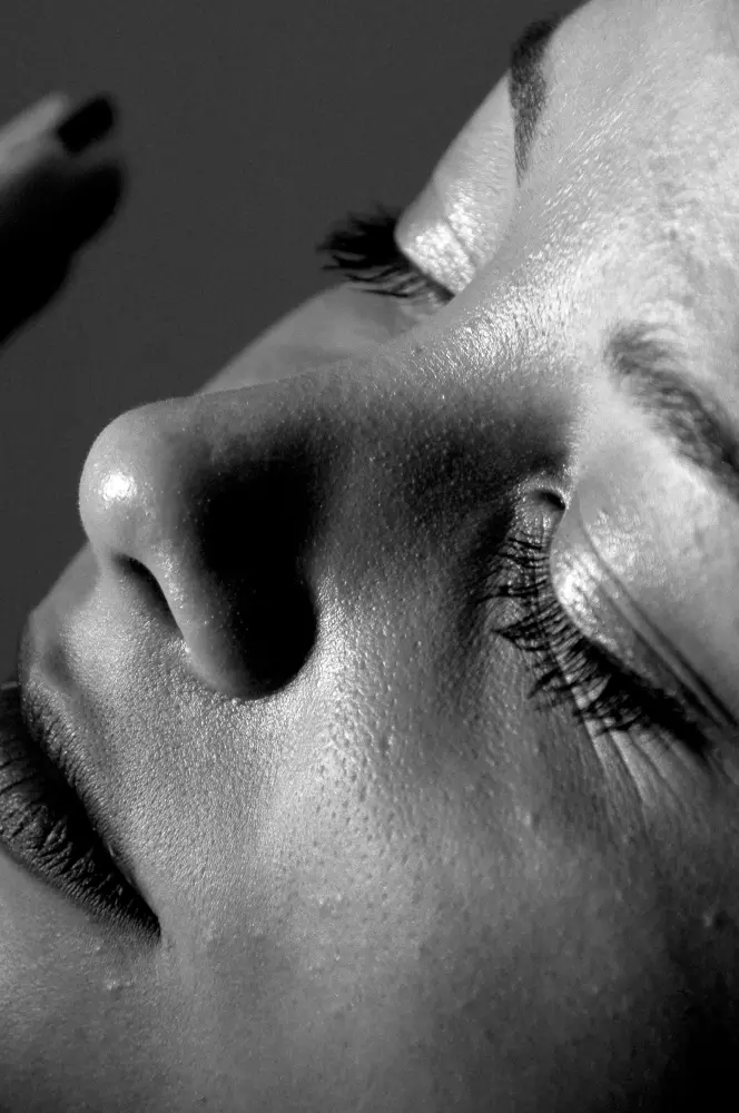 Eine Frau lässt sich von einem Friseur die Wimpern machen.