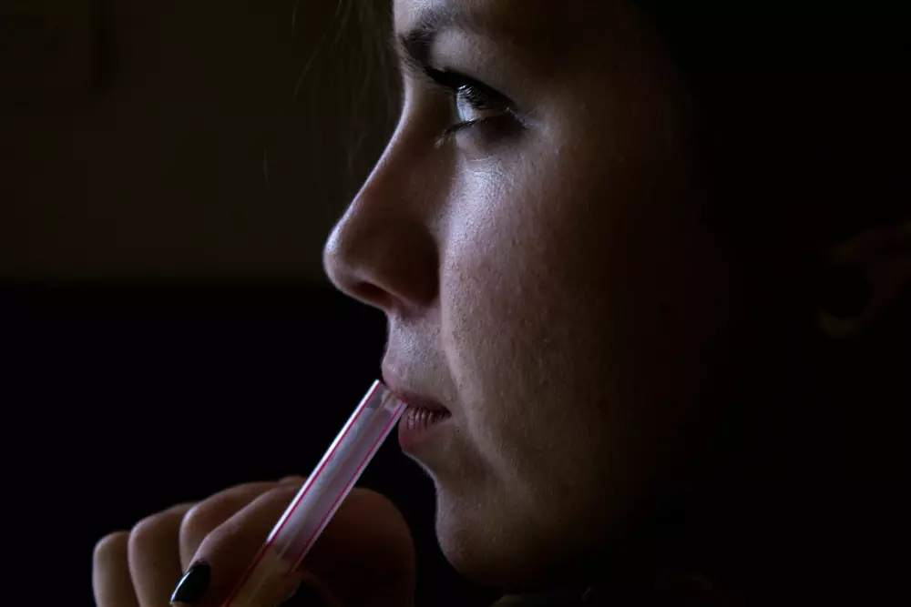 a woman with a pink toothbrush in her mouth
