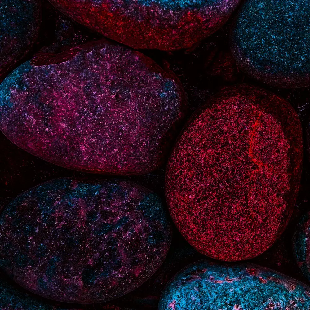 Eine Menge von Steinen, die mit lila und roter Farbe bedeckt sind.