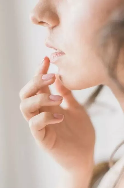 a woman's face with her hand on her chin