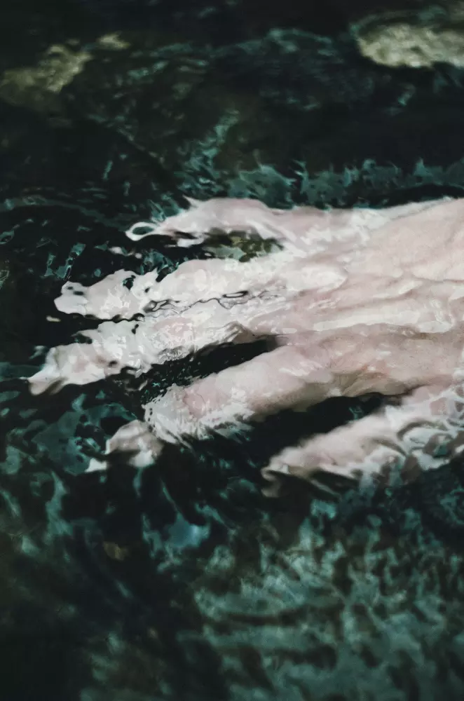 Die Füße einer Person im Wasser an einem sonnigen Tag