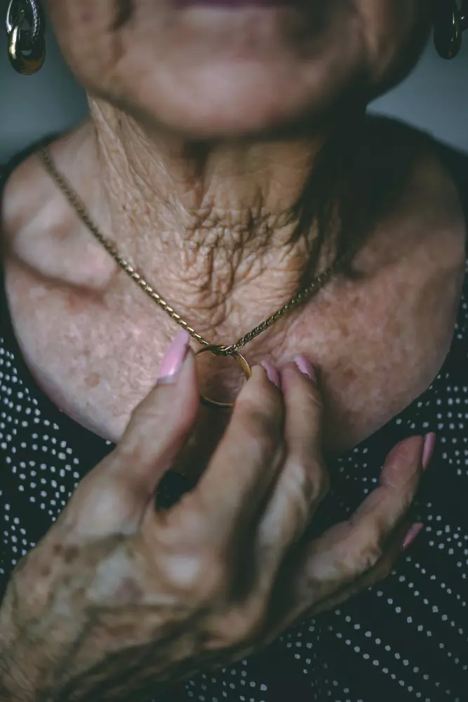 an older woman holding her hands together to her chest