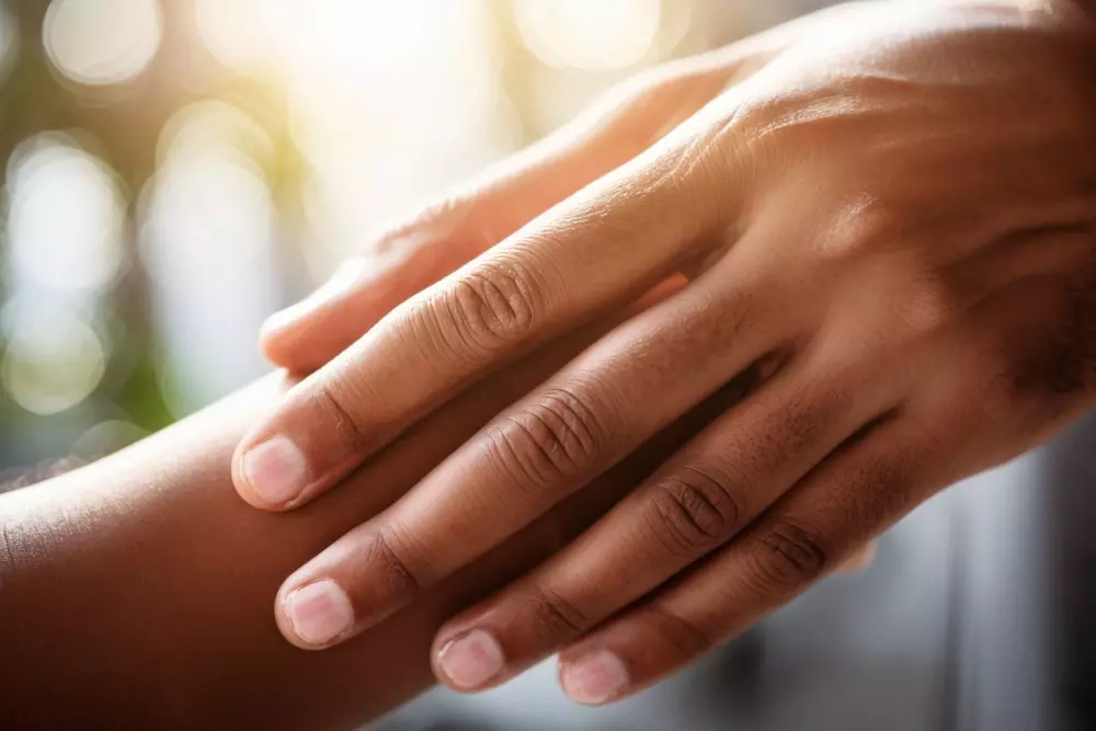 Nahaufnahme einer Hand, die sanft die glatte und feste Haut am Unterarm berührt, symbolisiert Hautpflege und Verjüngung, fotografiert mit einem Makroobjektiv bei weichem natürlichem Licht.