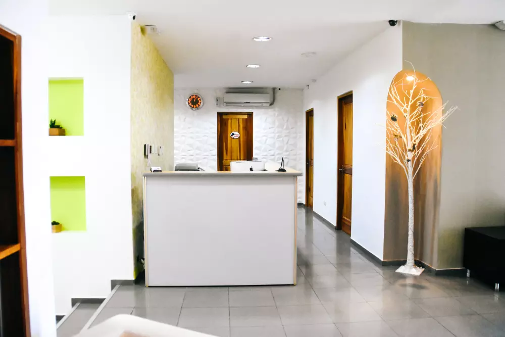 a kitchen with a white counter top next to a black couch