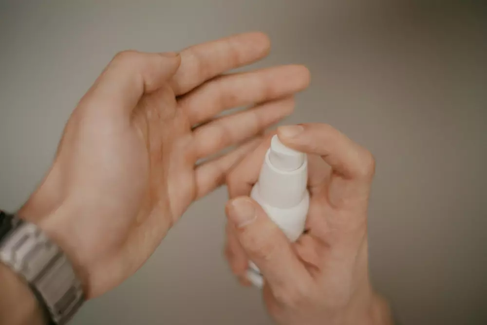 a person holding a bottle of lotion in their hand