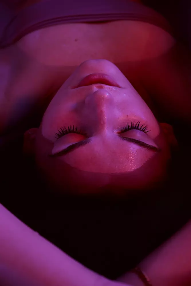 a woman laying down with her eyes closed