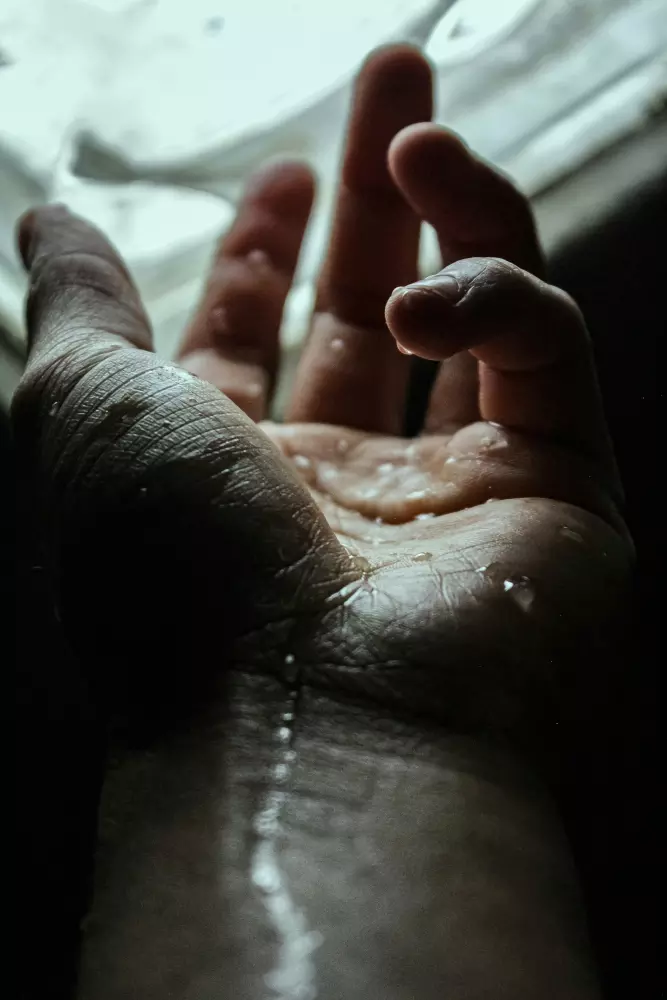 Eine Hand einer Person mit Wasser darauf