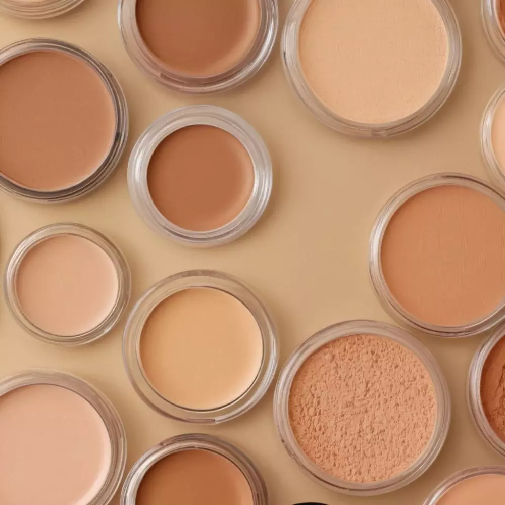 Array von Make-up-Produkten, die sich auf Concealer und Foundations für Haut mit Pigmentflecken konzentrieren, mit sauberem Hintergrund und hoher Auflösung.