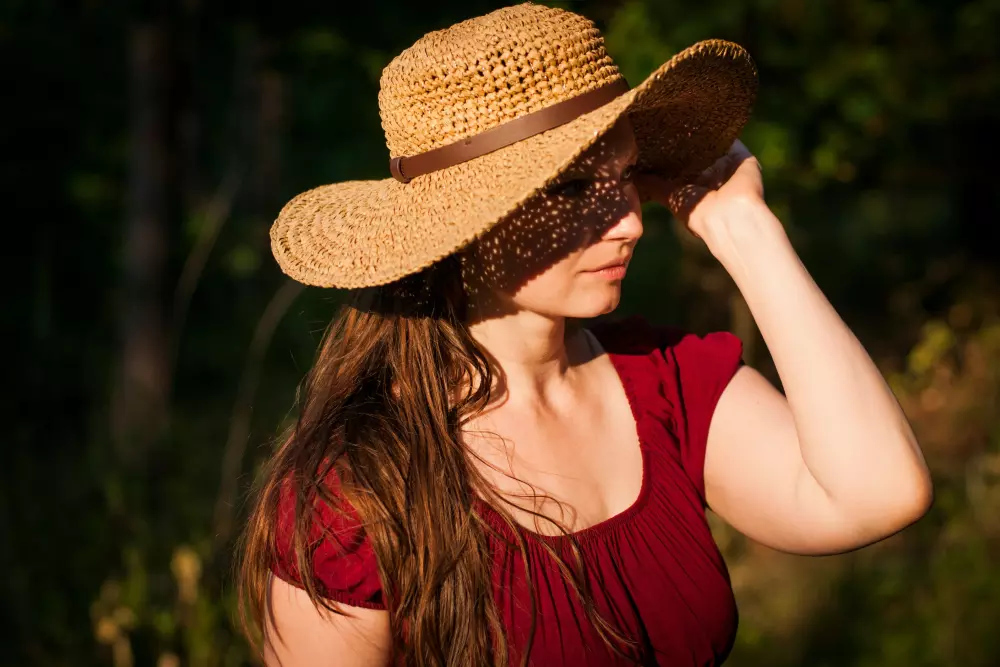 a woman in a red shirt and a brown hat