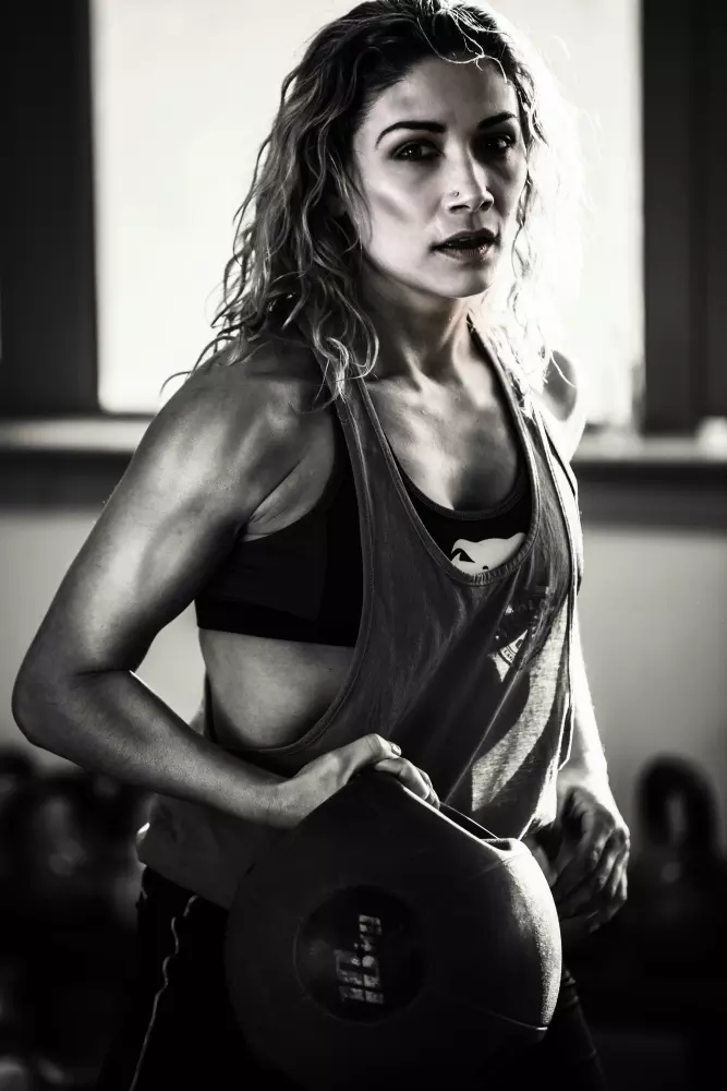 Eine Frau in einem Sport-BH, der einen Ball hält