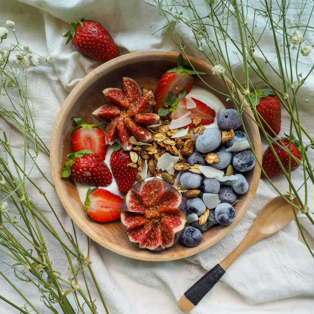 eine hölzerne Schale gefüllt mit Obst und Nüssen