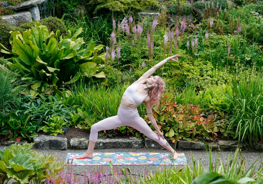 Eine Frau macht Yoga in einem Garten