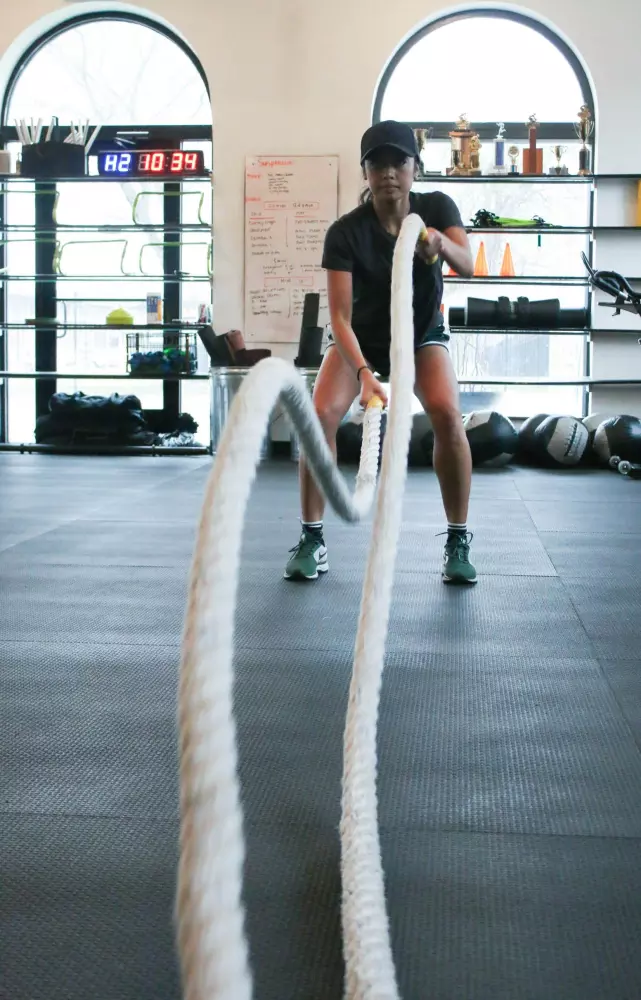 una mujer sosteniendo una cuerda en un gimnasio