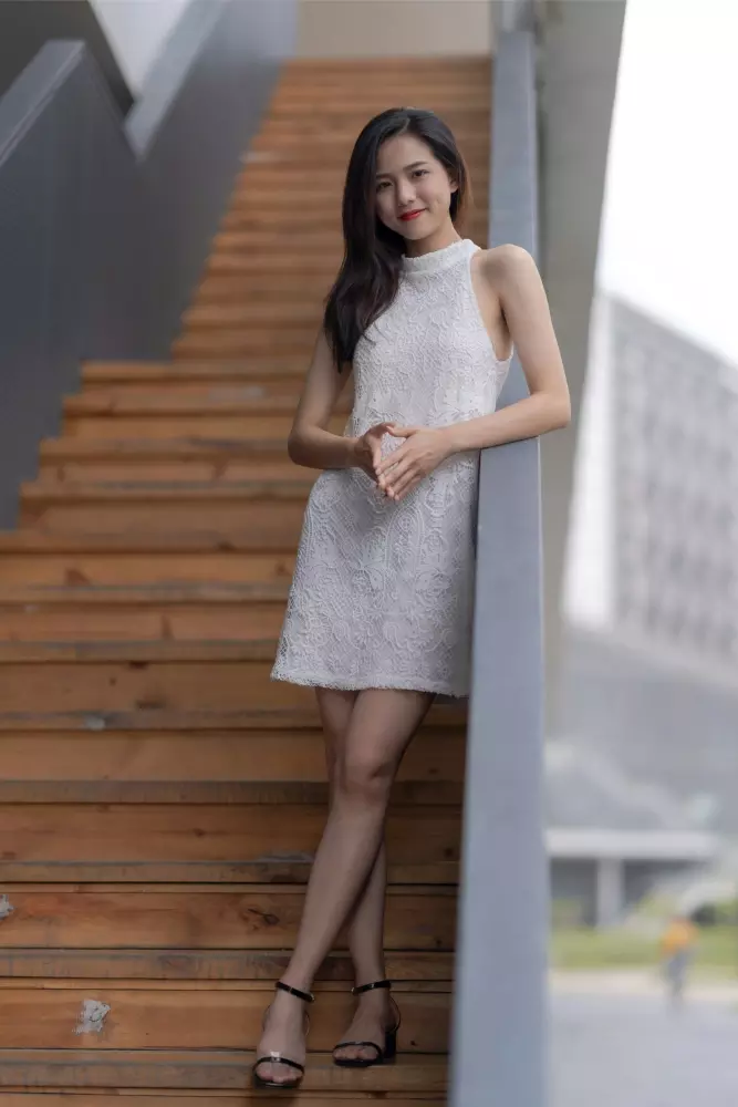 Eine Frau in einem weißen Kleid steht auf einer Treppe.