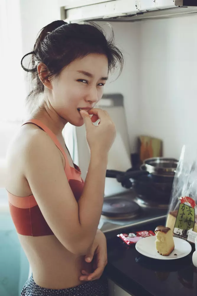 Eine Frau steht vor einem Herd mit Kochplatten.