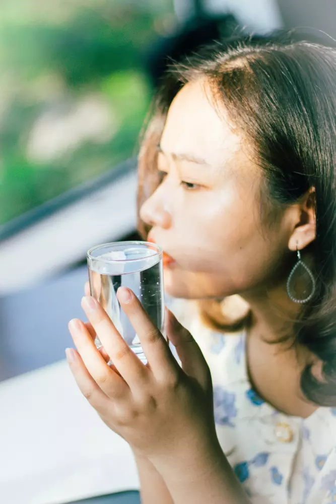 Eine Frau hält ein Glas Wasser in der Hand