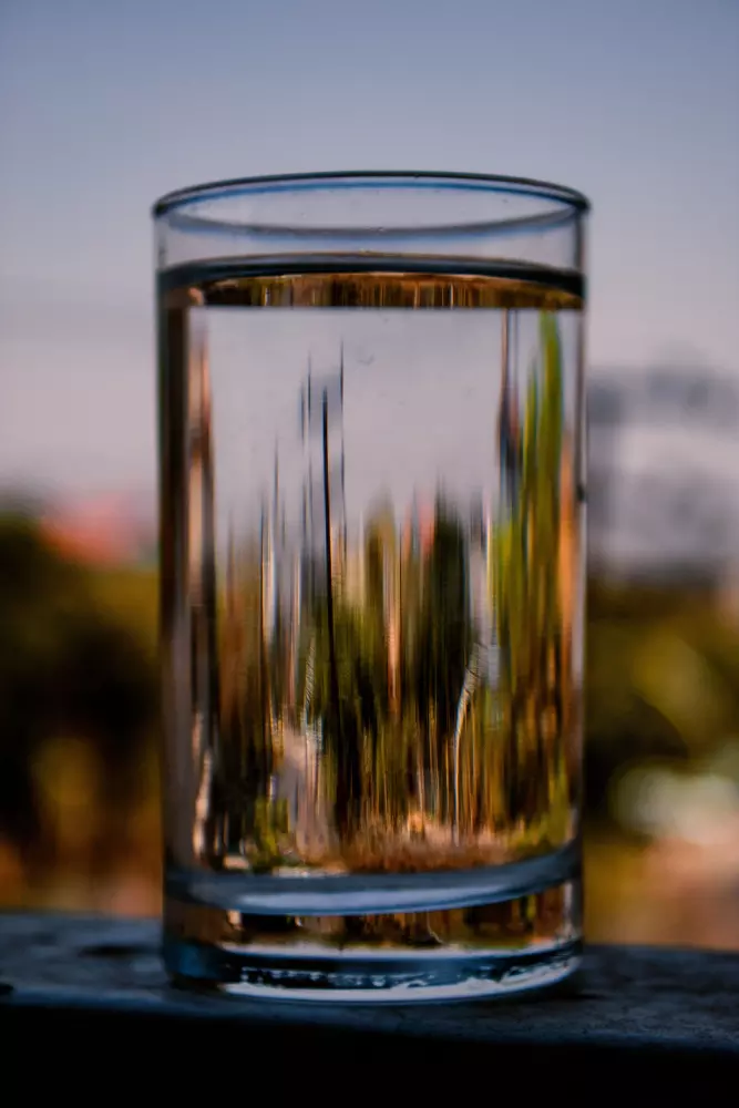un vaso de agua sobre una mesa de madera