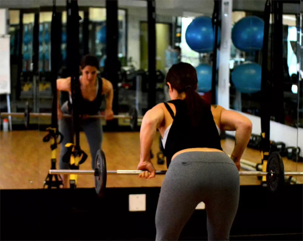 Ein Mann und eine Frau machen Kniebeugen im Fitnessstudio.