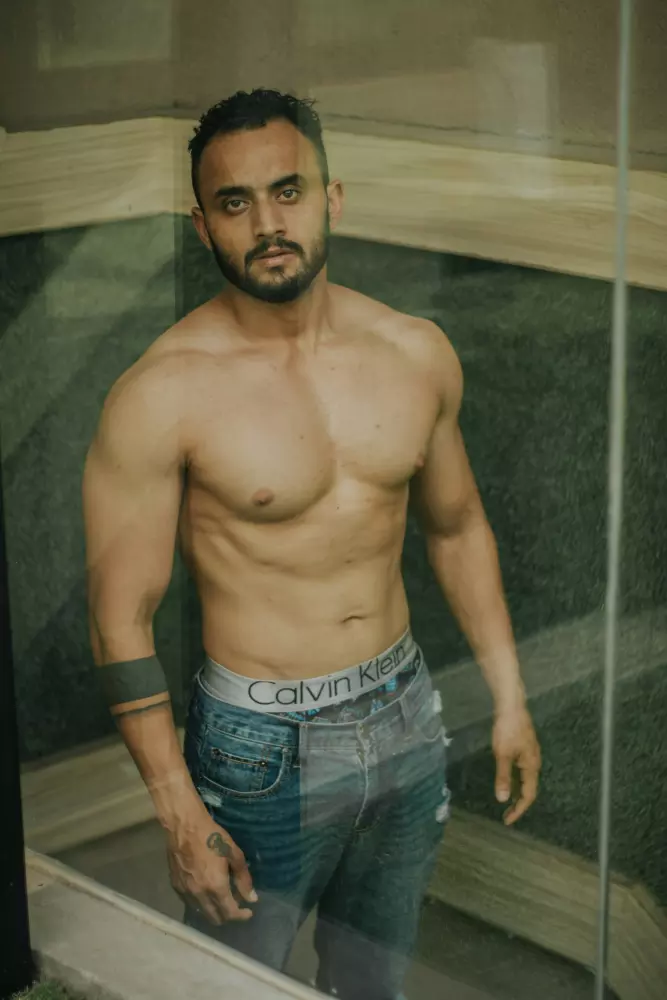 Ein nackter Mann steht vor einem Fenster