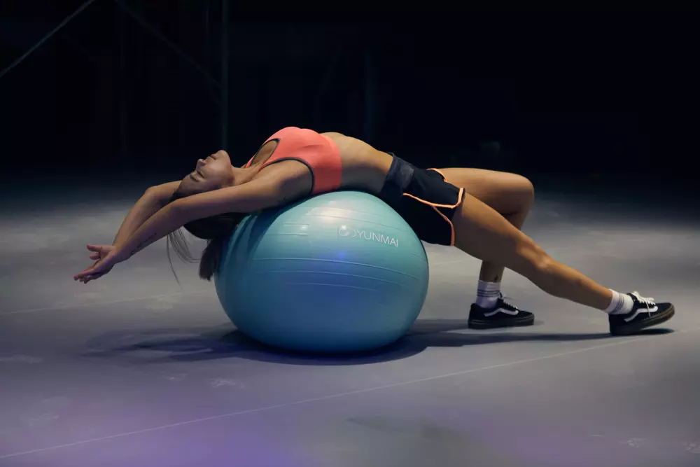 Eine Frau macht Übungen auf einem Gymnastikball.