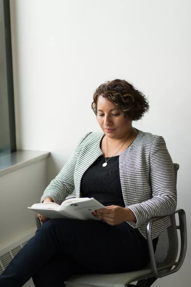 una mujer sentada en una silla leyendo un libro