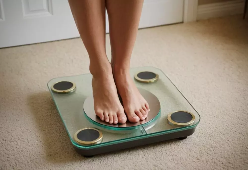 Primer plano de una báscula con pies de mujer, mostrando aumento de peso, en un entorno hogareño, con una atmósfera enfocada y personal, fotográfico, realizado a través de fotografía en primer plano con luz suave y alta resolución.
