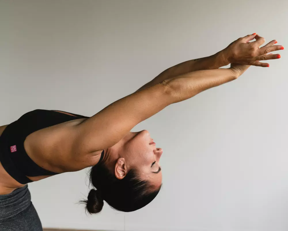 a woman doing a handstand on a yoga mat