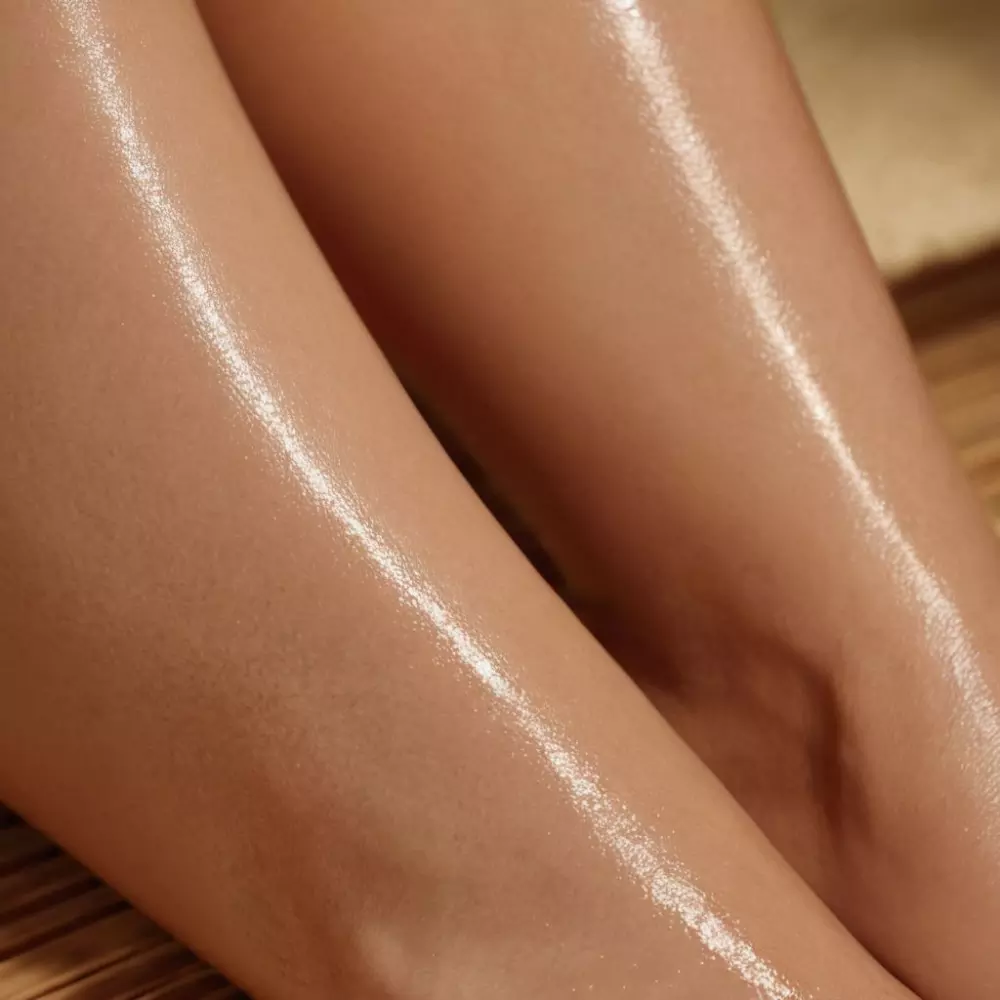 Primer plano de las piernas de una mujer mostrando una piel suave después de un tratamiento de presoterapia, en un entorno de spa tranquilo y relajante. Fotografía tomada con una cámara DSLR de alta resolución capturando la textura de la piel y la iluminación ambiental del spa.