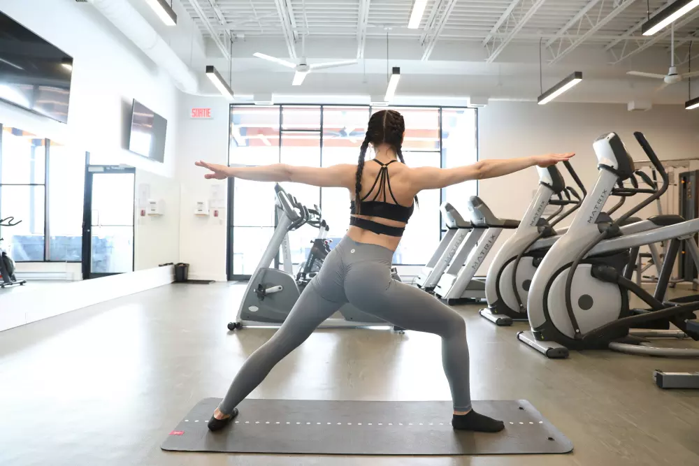 Una mujer está haciendo yoga en un gimnasio
