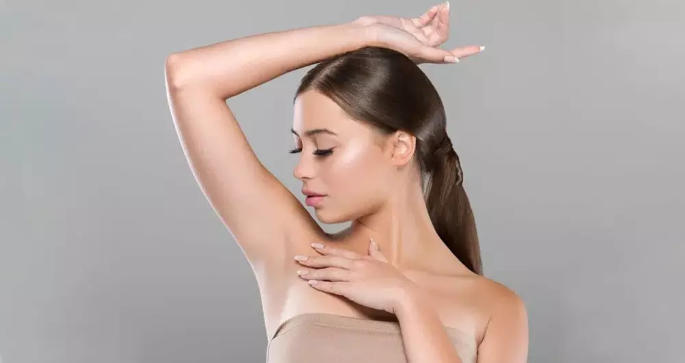 a woman is posing with her hand on her arm