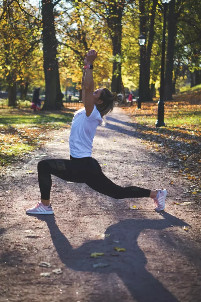 Eine Frau macht eine Yoga-Pose in einem Park.