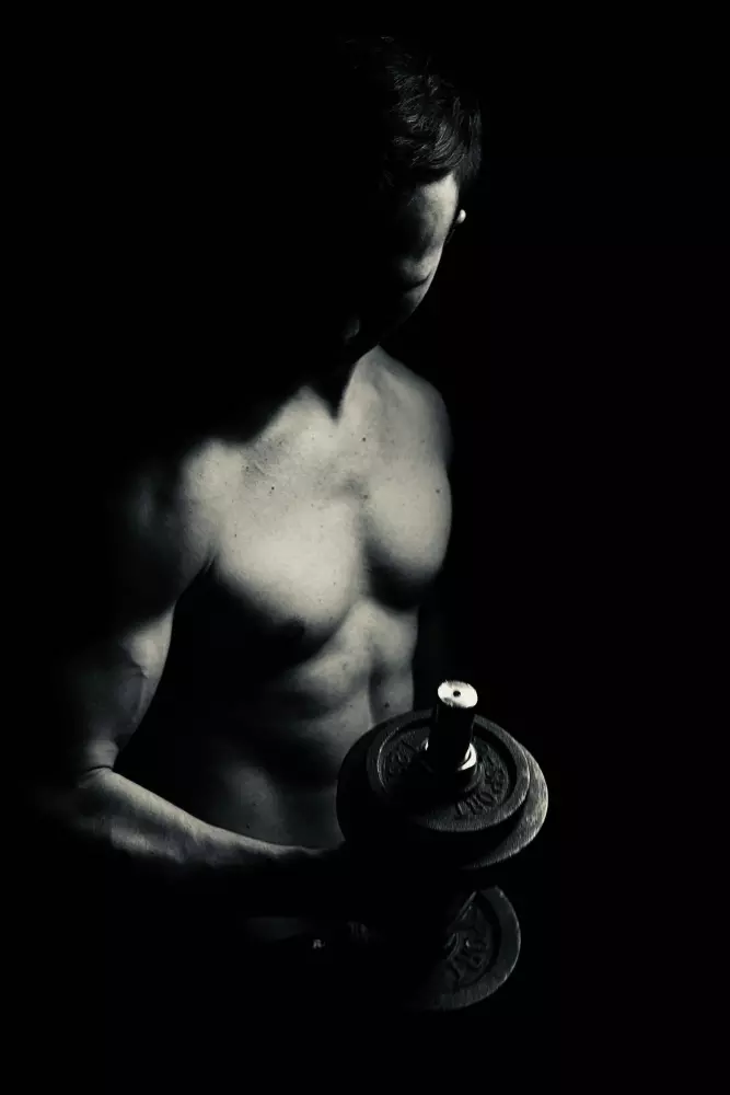 Ein Mann ohne Hemd, der Dum-Dums hält.