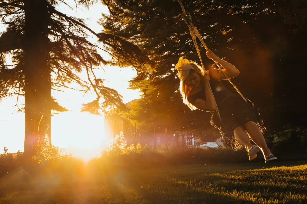 Eine Frau schaukelt auf einer Schaukel in einem Park.