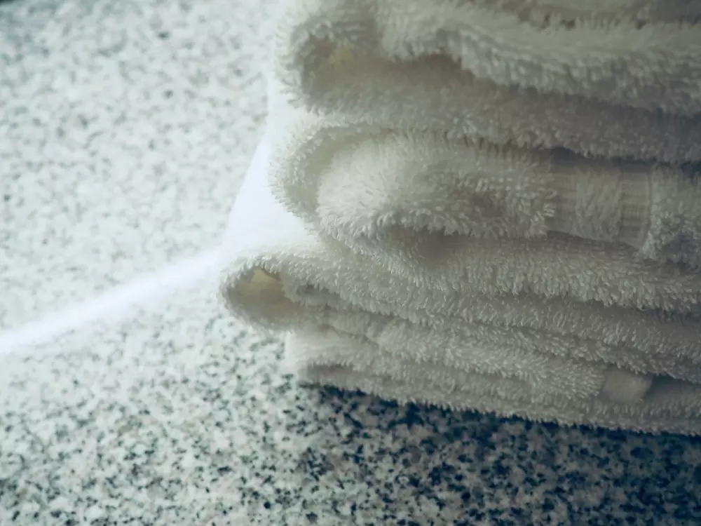 Ein Stapel weißer Handtücher liegt auf einer Theke.