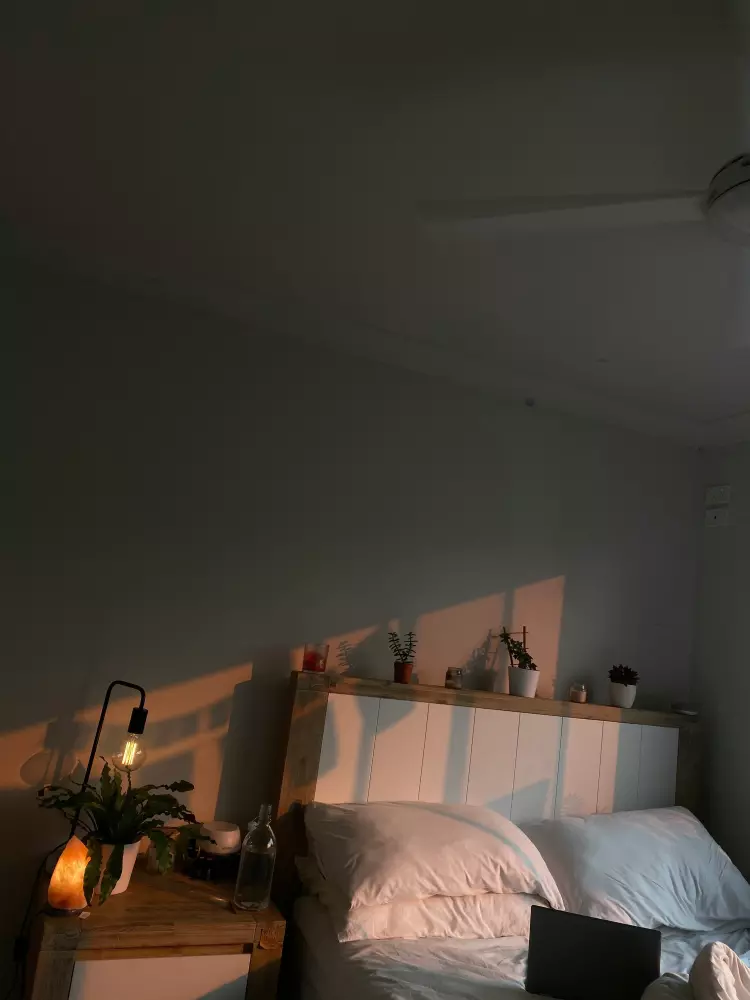 Ein Schlafzimmer mit einem Bett und einem Schreibtisch, auf dem ein Laptop steht.