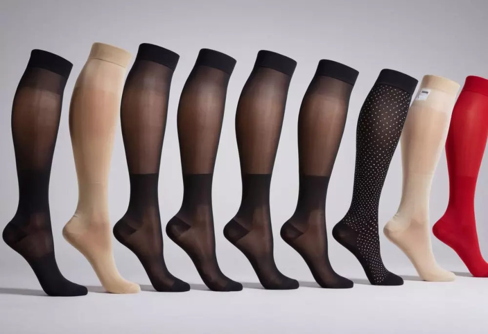 Verschiedene Arten von Kompressionsstrümpfen werden präsentiert, wobei der Fokus auf verschiedenen Webarten und Längen liegt, mit sichtbaren Etiketten. Fotografisch, mit detailliertem Fokus auf Stoffarten.