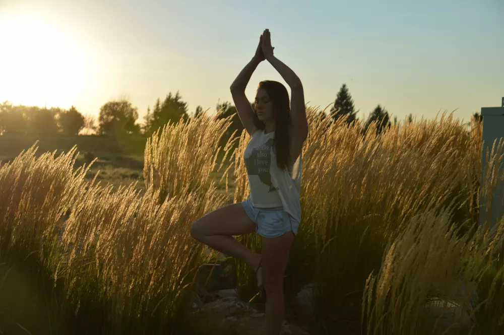 Eine Frau steht auf einem Feld mit den Händen in der Luft.
