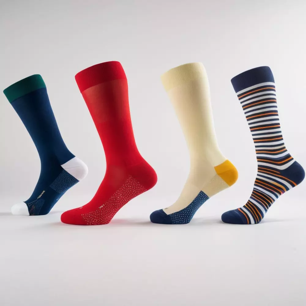 Eine Tabelle, die verschiedene Kompressionsklassen von Socken zeigt, jede beschriftet und farbcodiert, auf einem sauberen, weißen Hintergrund dargestellt, entworfen, um jede Klasse klar voneinander abzugrenzen. Fotografischer Stil, umgesetzt durch hochauflösende digitale Fotografie mit scharfem Fokus und Studio-Beleuchtung.