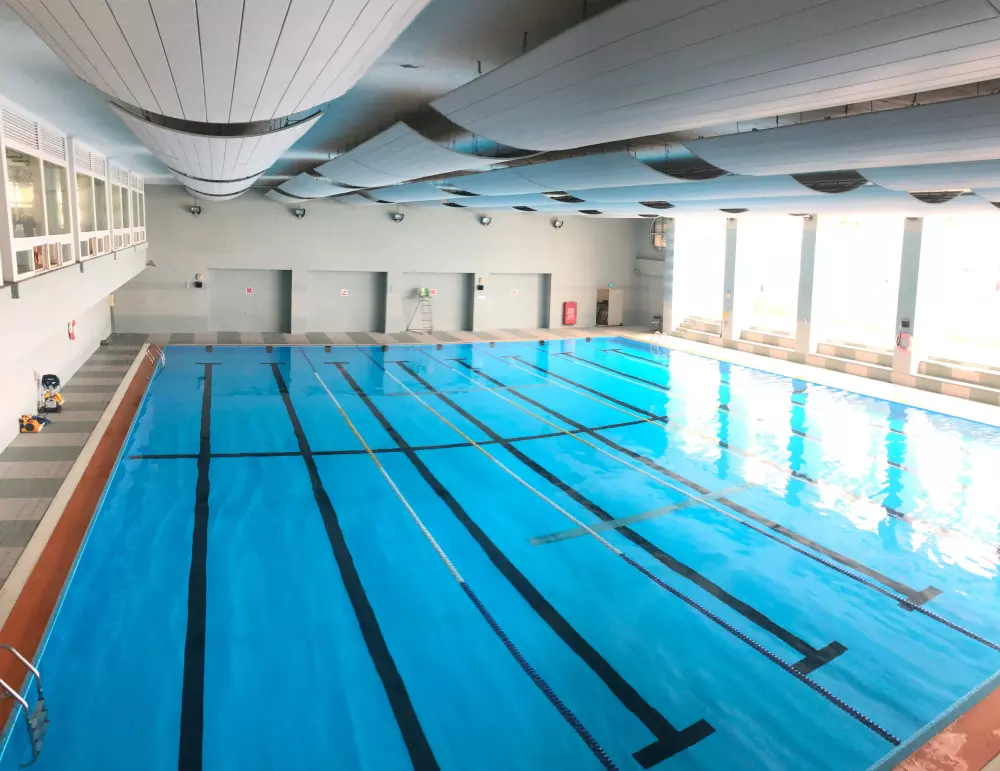 ein großes Schwimmbad mit blauem Wasser in einem Gebäude