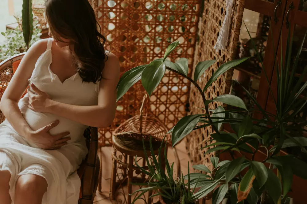 Eine Frau in einem weißen Kleid, die ein Baby hält