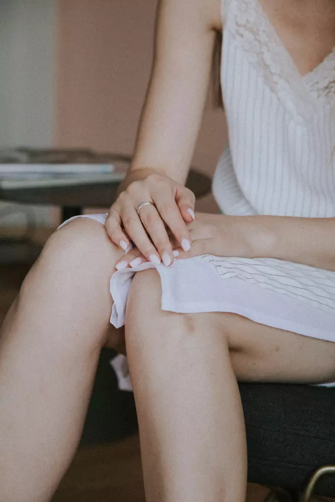 Eine Frau sitzt auf einem Stuhl mit überkreuzten Beinen.