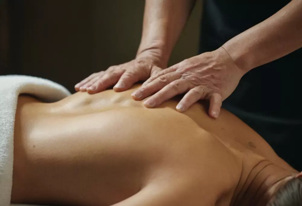 Nahaufnahme von den Händen eines Therapeuten, der präzise Lymphdrainage-Techniken am Rücken eines Klienten anwendet, klare Fokussierung auf Hände und Haut, Fotografie, Nahaufnahme mit natürlichem Licht und detailreicher Textur.