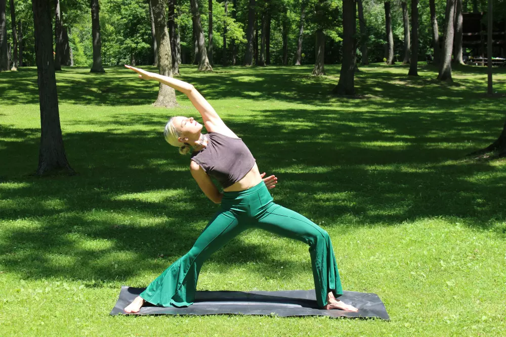 Eine Frau in einer Yoga-Pose auf einer Matte in einem Park