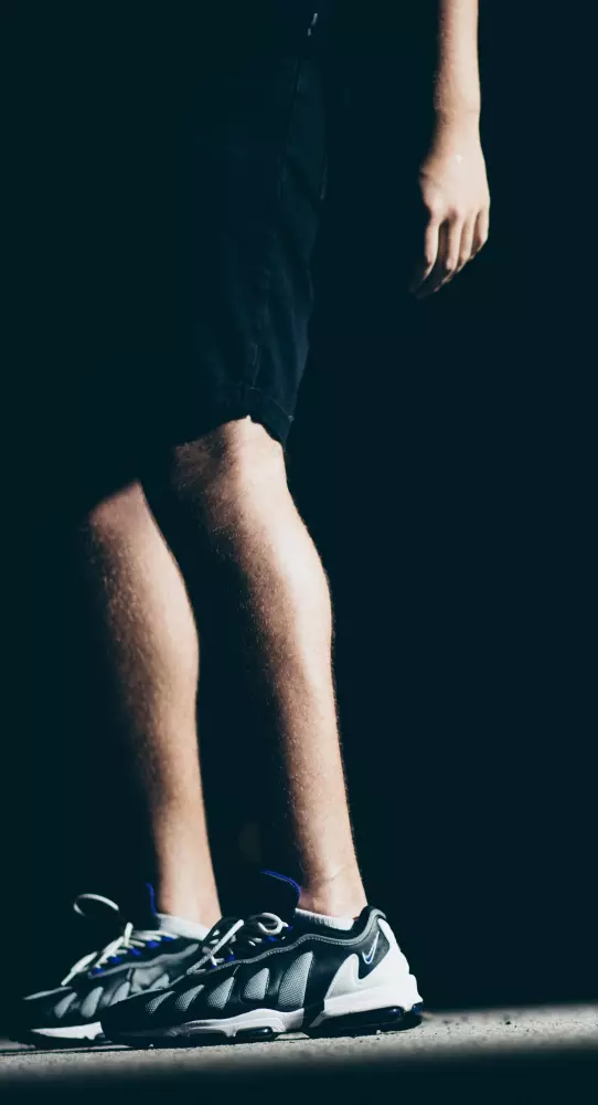 Eine Person steht auf einem Skateboard im Dunkeln.