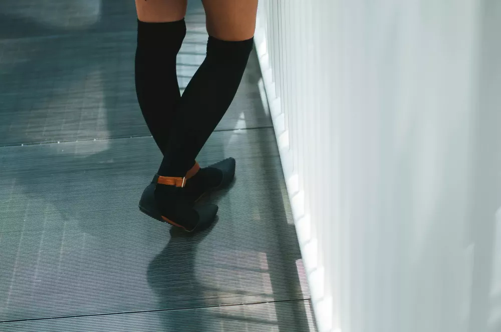 Die Beine einer Frau mit schwarzen Socken und High Heels