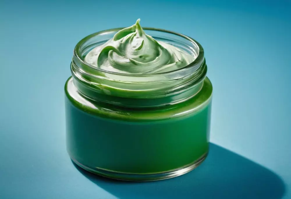 Ein Glas mit Algencreme, bei dem die Textur der Creme sichtbar ist, auf einem ruhigen blauen Hintergrund platziert, fotografische, detaillierte Nahaufnahme mit weichem Studio-Licht.
