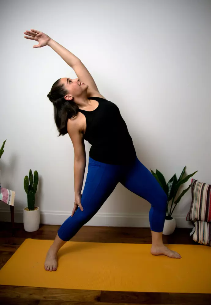 Eine Frau macht eine Yoga-Übung auf einer Matte.