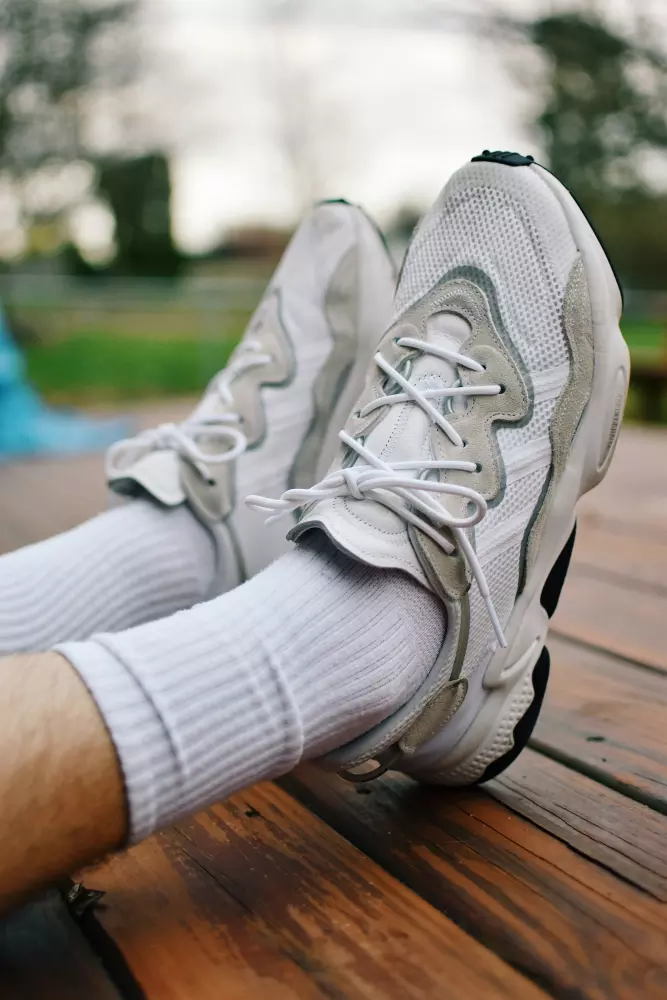 eine Person, die weiße Socken und weiße Turnschuhe trägt